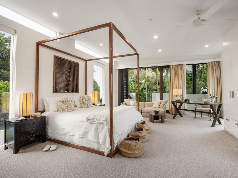 Four-poster bedroom opening to tropical garden greenery