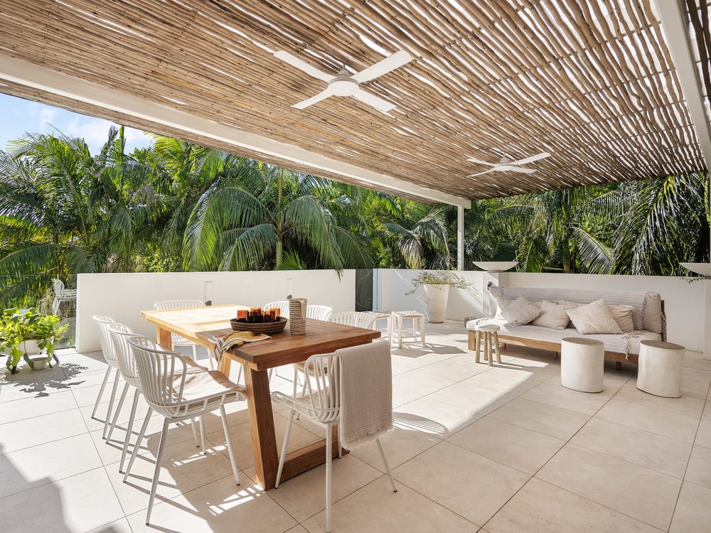 Covered dining terrace surrounded by lush tropical palms